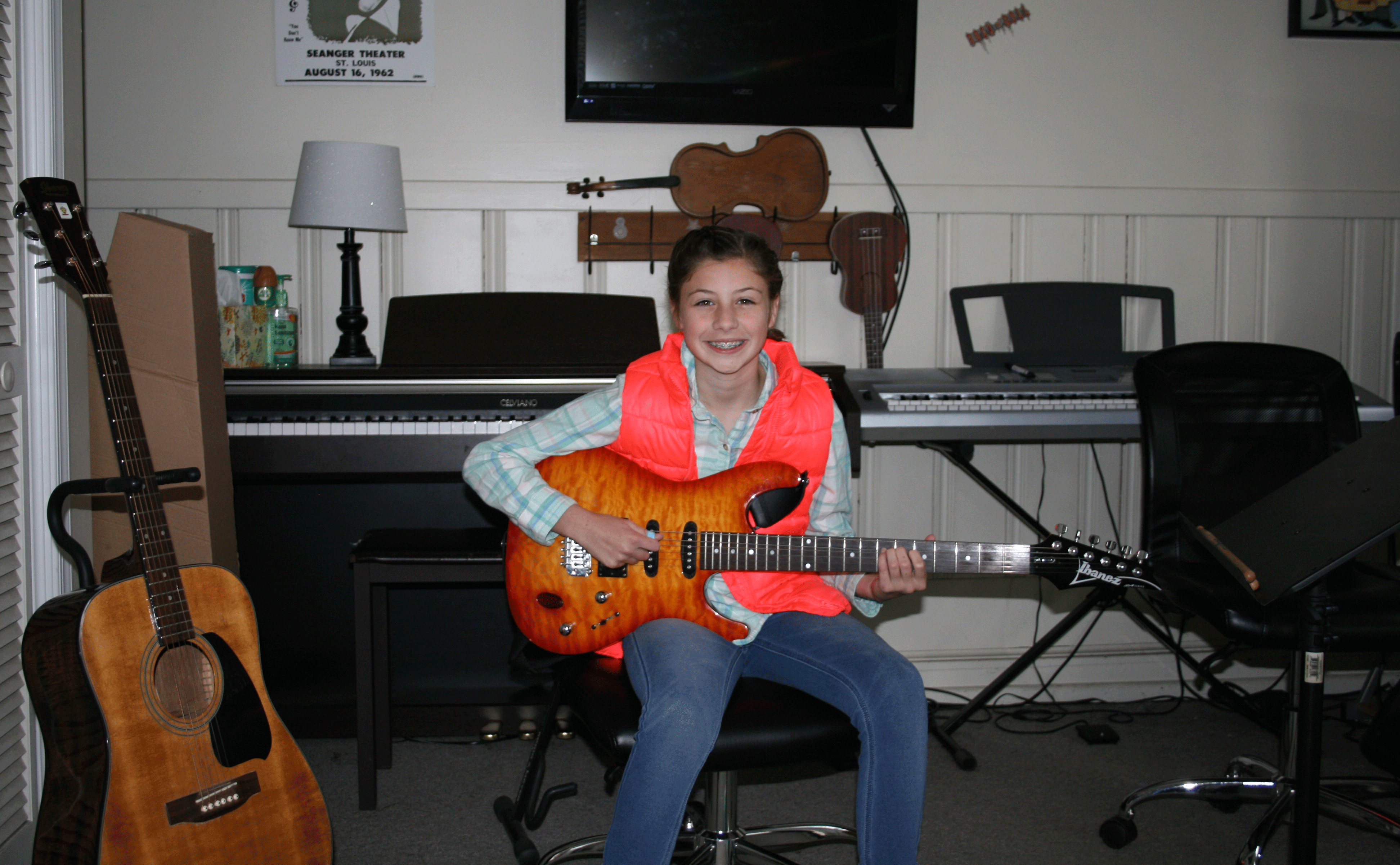 Girl with guitar, on line music lessons, music lessons, pianos, flat screen TV, electric guitar, acoustic guitar